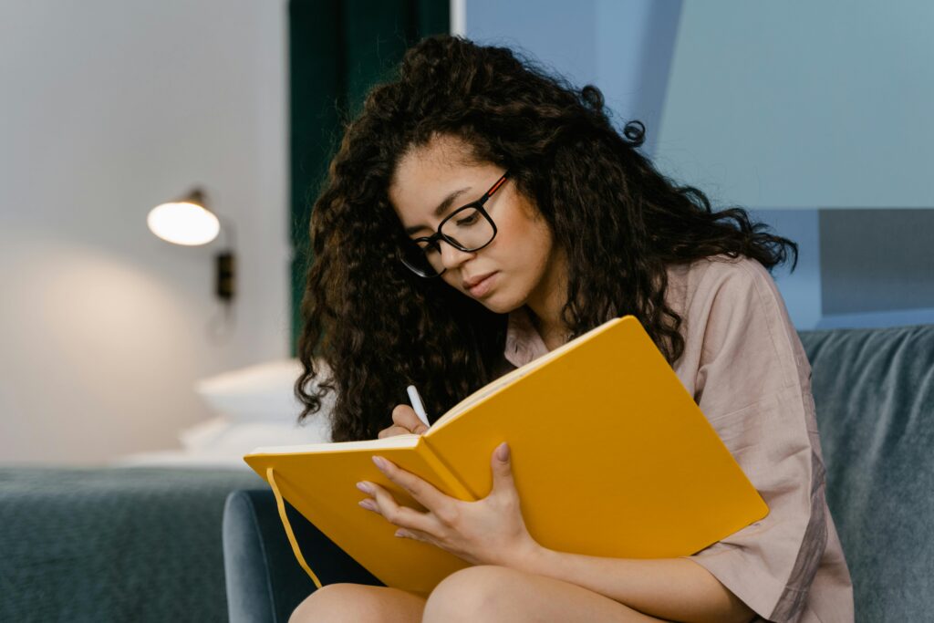A woman writing in a journal.